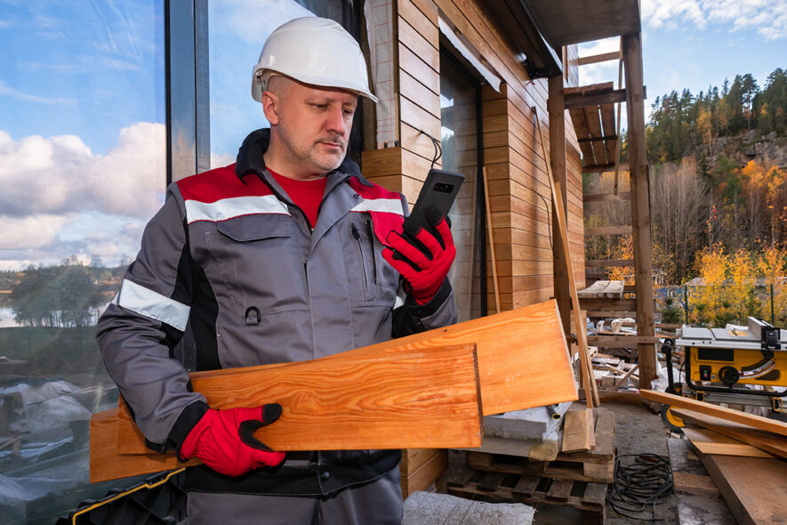 Tradie with a mobile phone on a construction site.