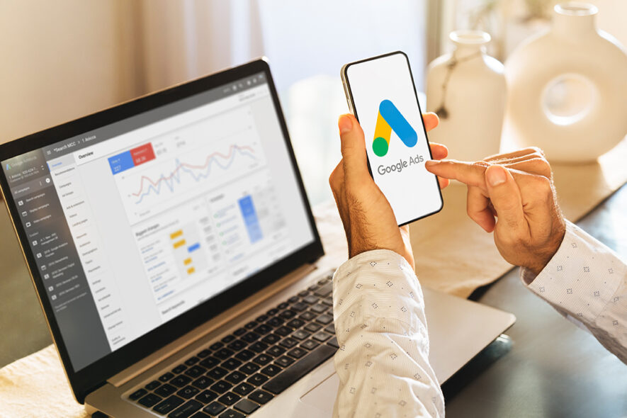 Man using a mobile phone with Google Ads on the screen and in th